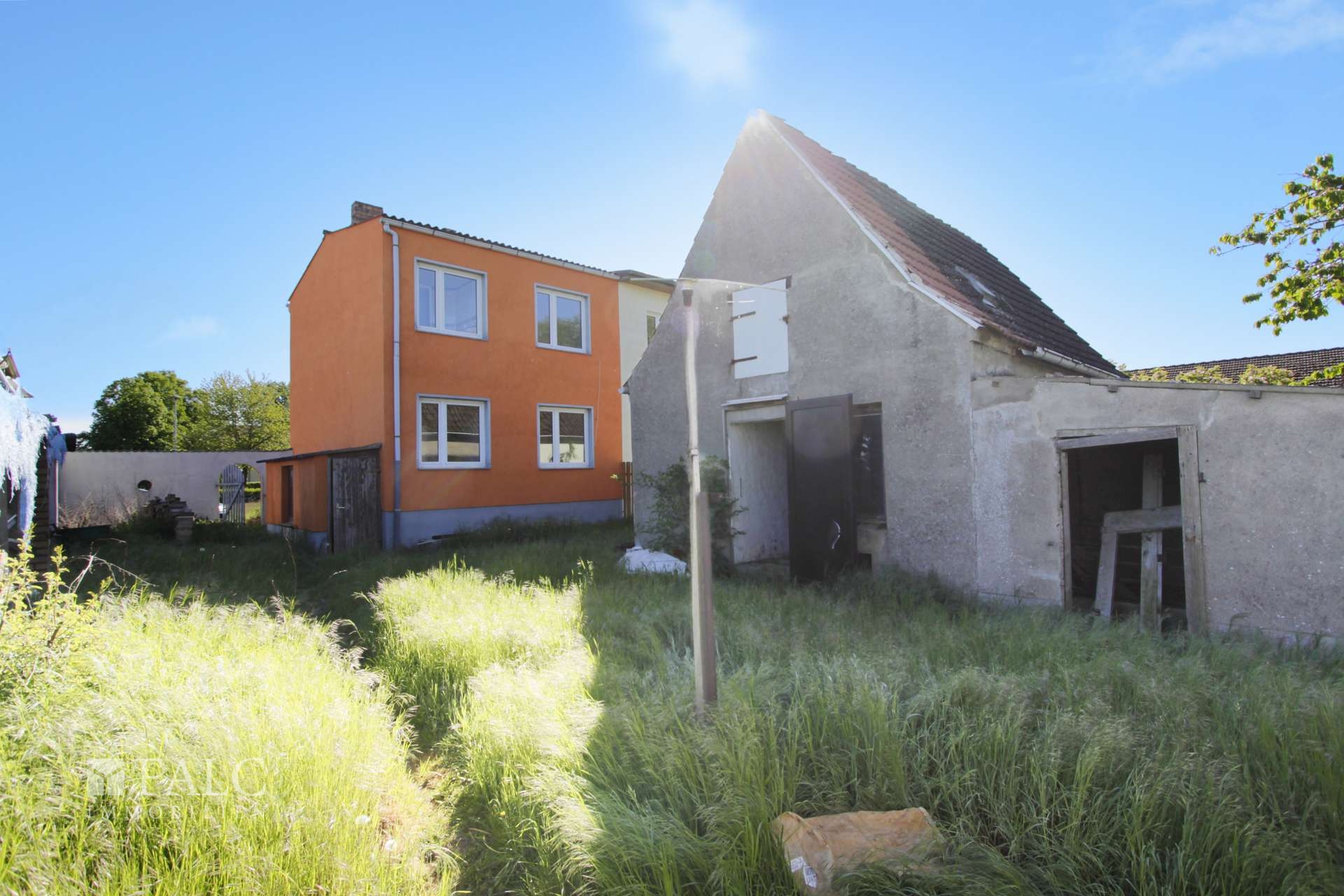 Blick auf Haus und Nebengebäude vom Garten